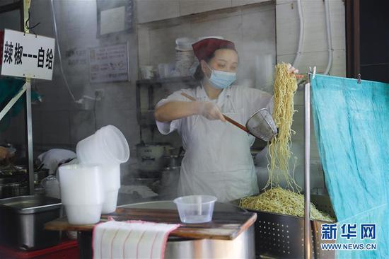 4月22日，武漢市糧道街的家陽“趙師傅”天天紅油熱干面店廚師在制作熱干面。新華社記者 沈伯韓 攝