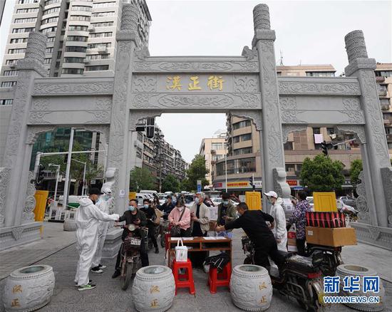  4月16日，進出武漢漢正街步行街的人員在掃描健康碼。新華社記者 王毓國 攝